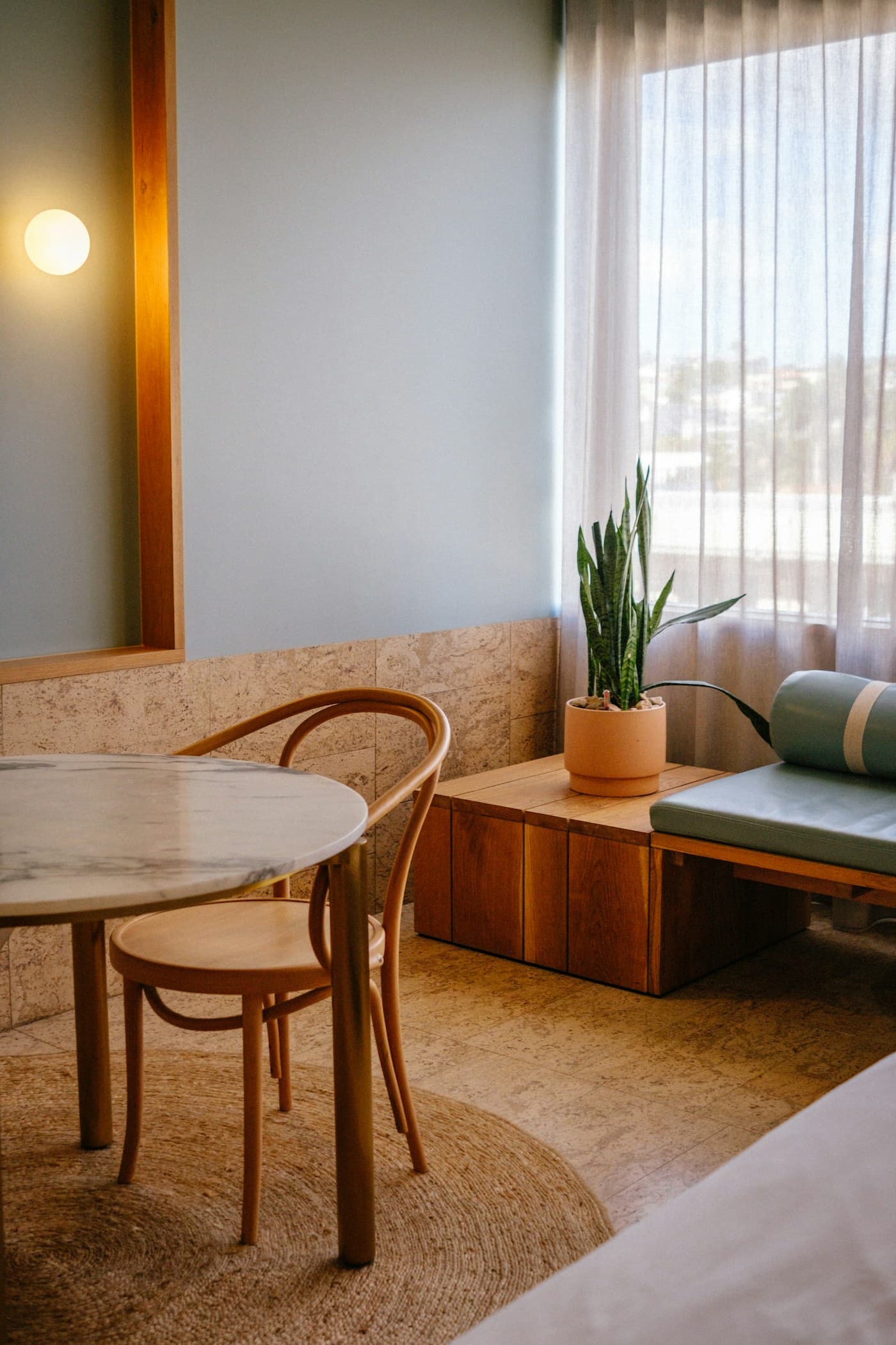A warm, minimal treatment room interior with a marble table and natural textures